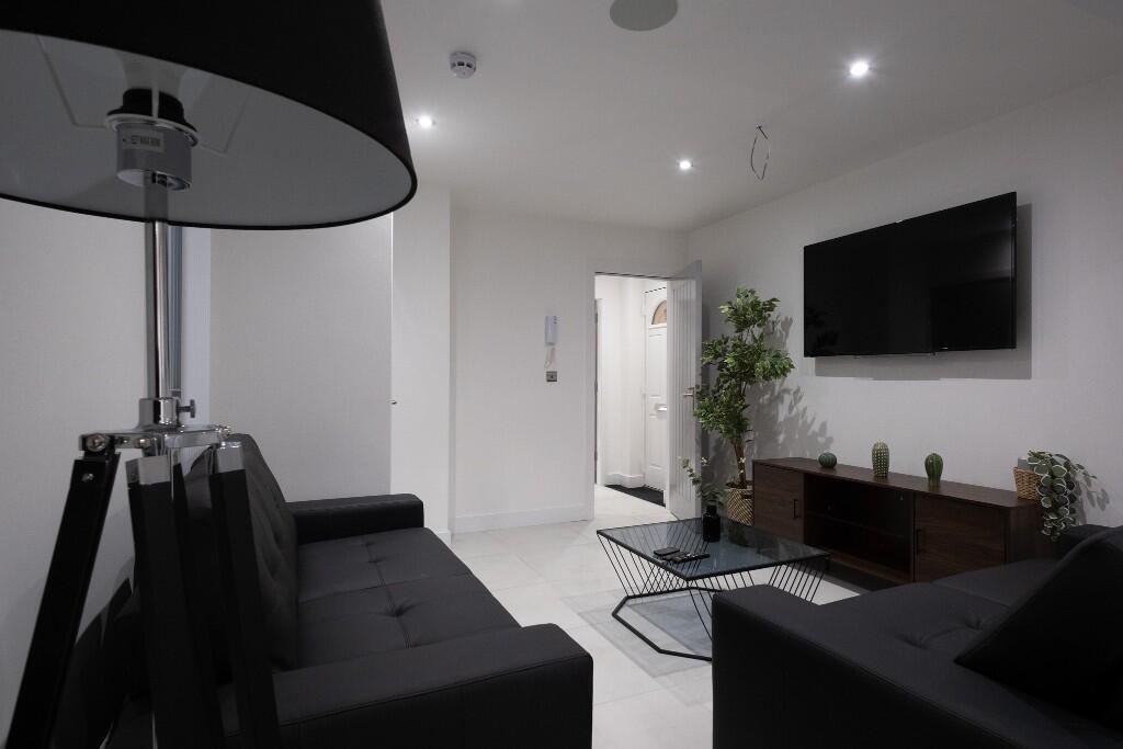 A modern living room featuring a sleek black so...