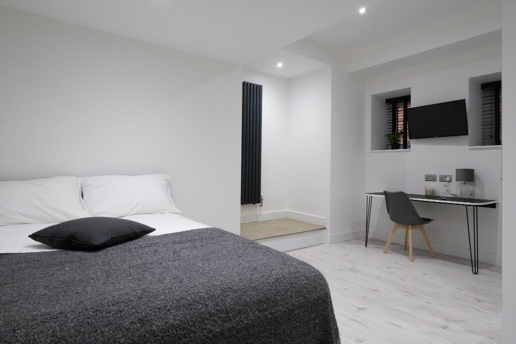 Bright, modern master bedroom with neutral deco...