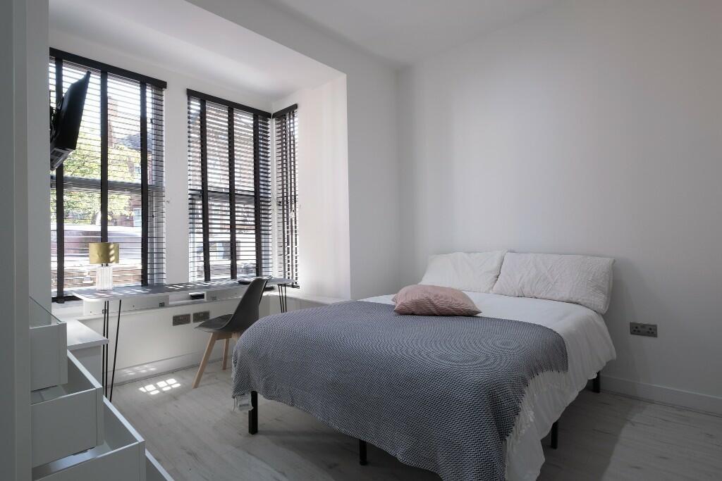 Bright, modern double bedroom with a comfortabl...