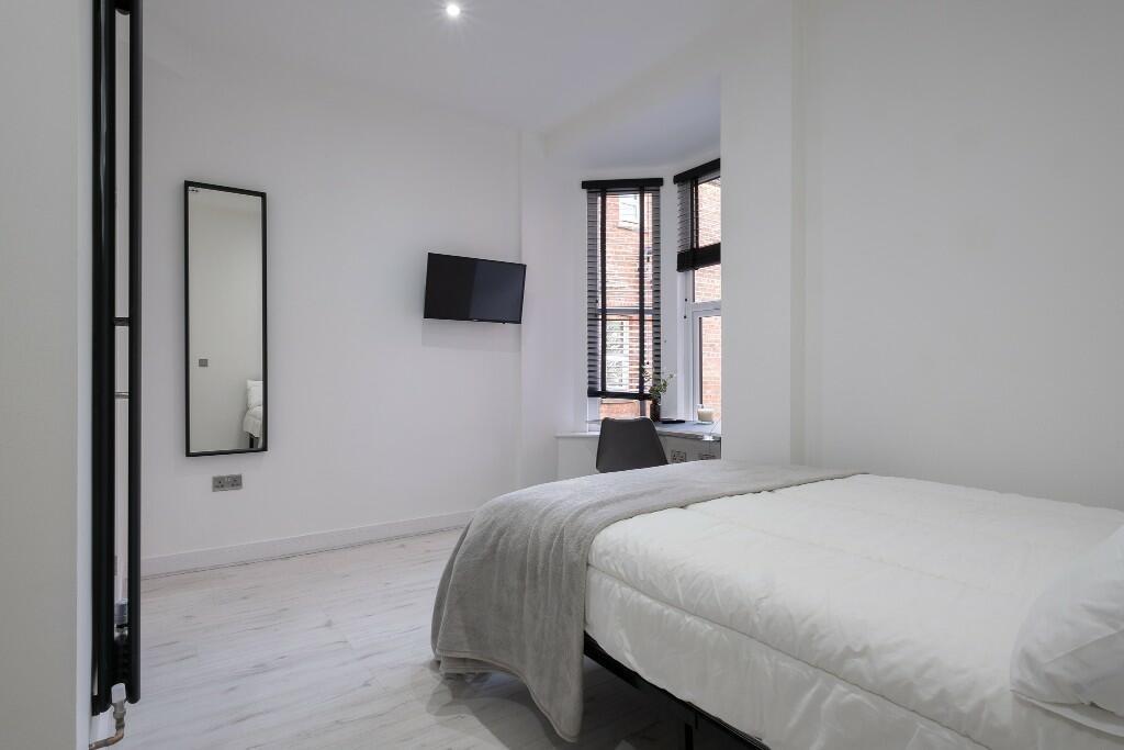 Bright, modern double bedroom with crisp white ...