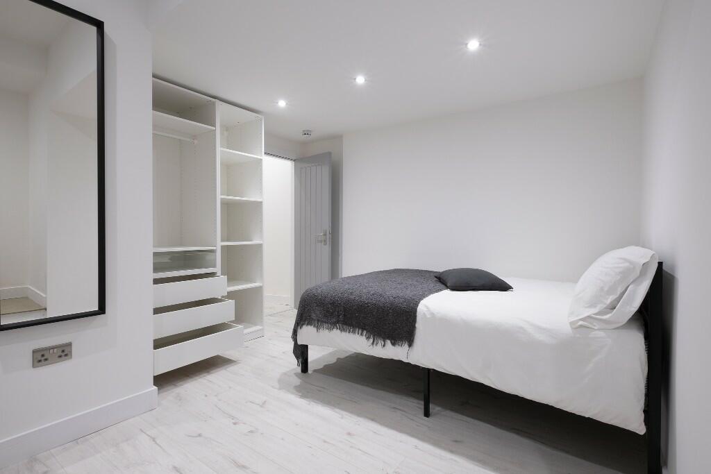 Bright, modern bedroom with clean white walls, ...