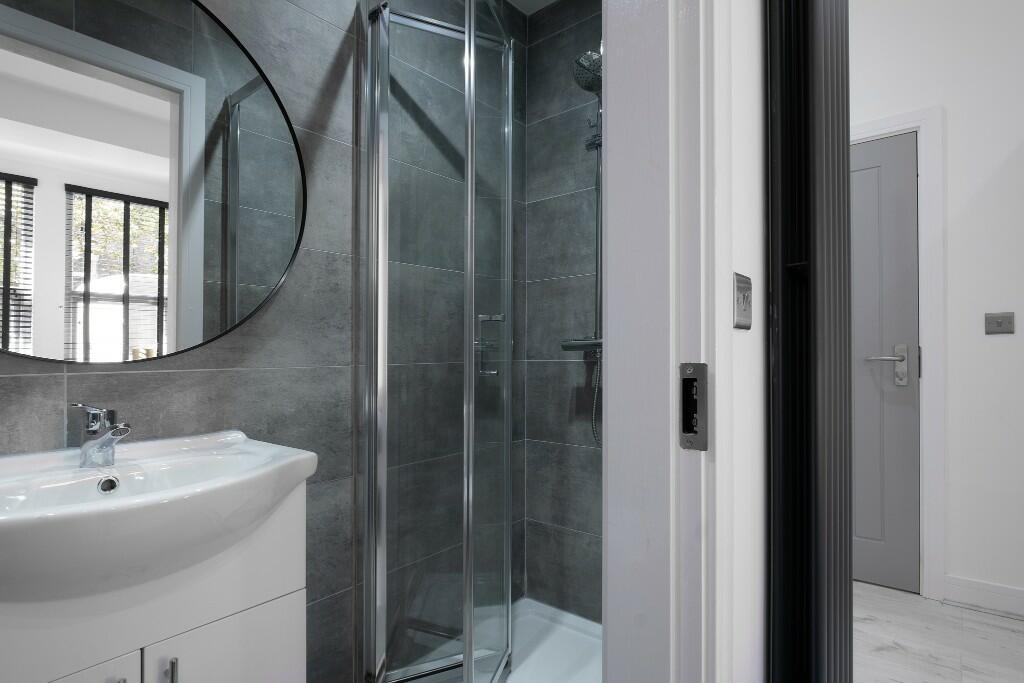Modern ensuite-style bathroom with a glass show...