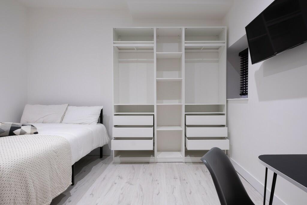 Bright, modern double bedroom with clean white ...