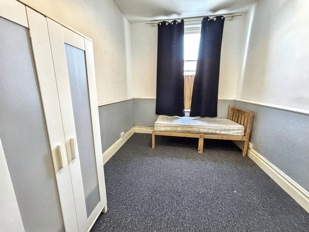 A small, tidy room with a bench placed under a ...