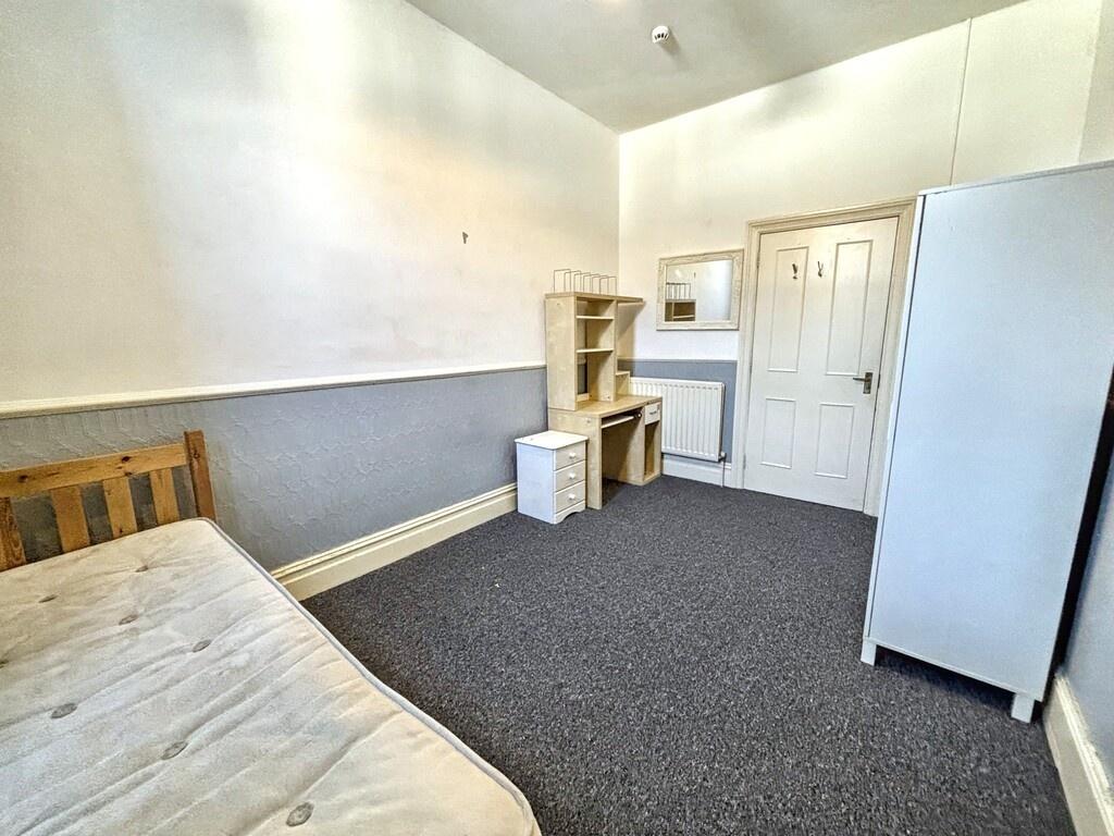 Bright, simply furnished bedroom with a single ...