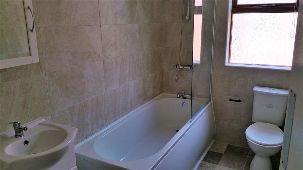 Bright, modern bathroom with a full-size bathtu...
