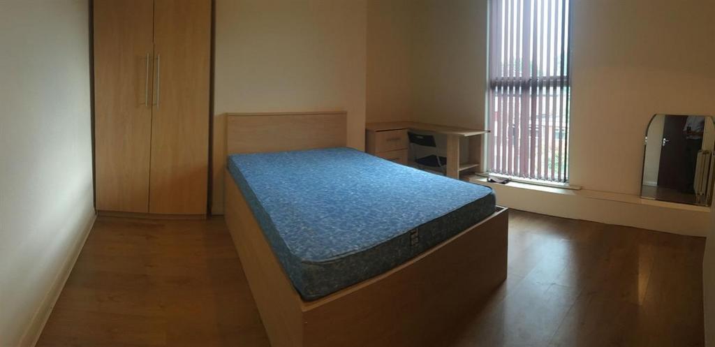 Bright, simply furnished bedroom with a double ...