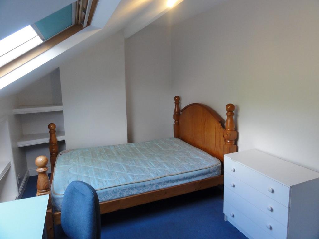 A cozy single bedroom with a wooden bed frame, ...