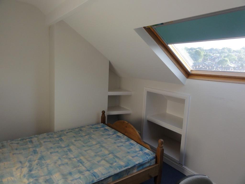 Bright and cozy bedroom with a sloped ceiling, ...