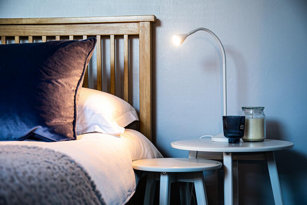 A cozy bedroom featuring a wooden slat headboar...