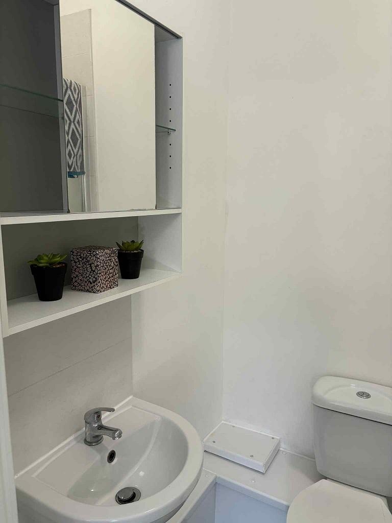 Bright, modern bathroom with a white basin, wal...