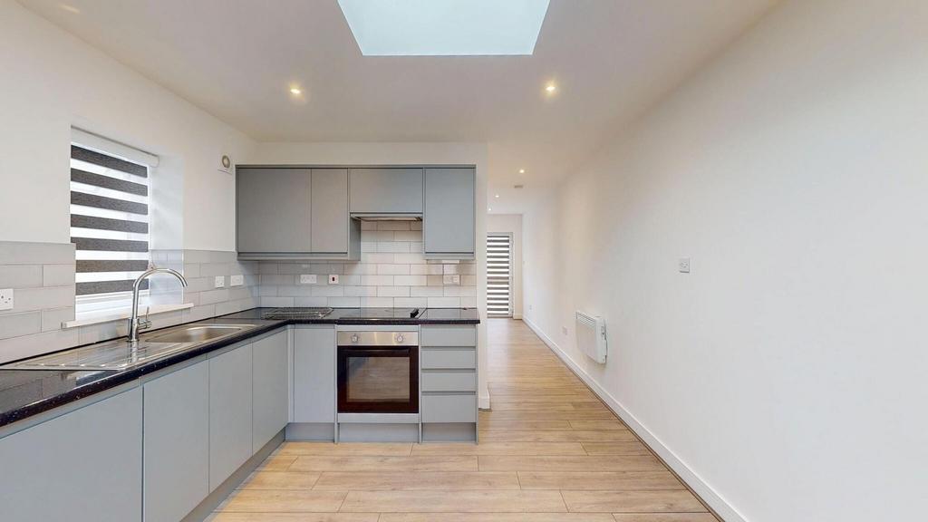 Bright modern galley kitchen with grey handlele...