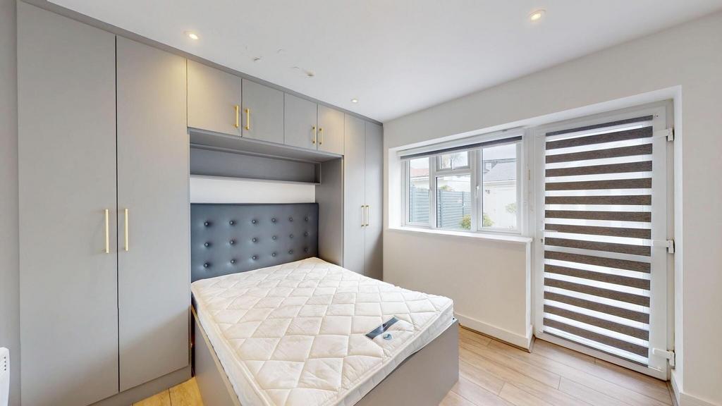 Bright, modern bedroom with built-in grey wardr...