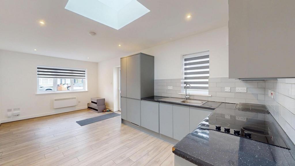 Bright, modern open-plan kitchen with sleek gre...