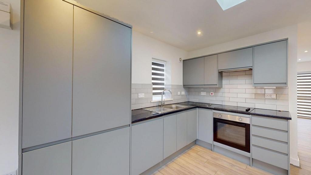 Modern L-shaped kitchen with sleek grey cabinet...