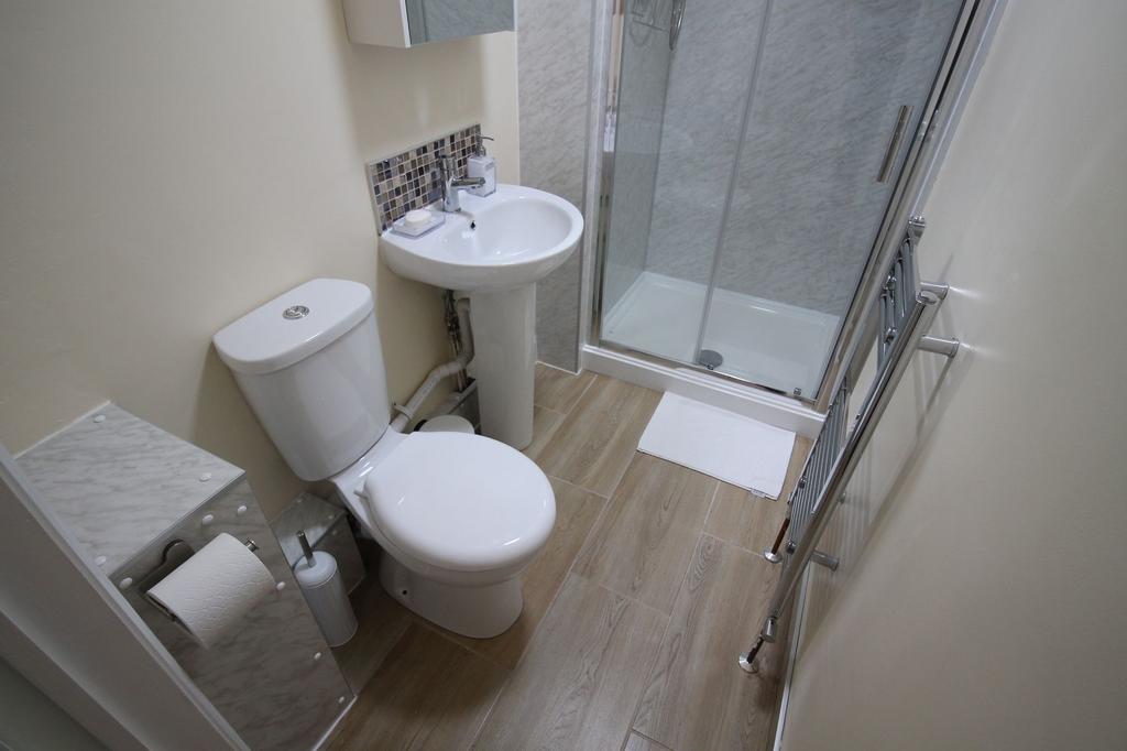 Bright, modern bathroom with a tiled shower cub...