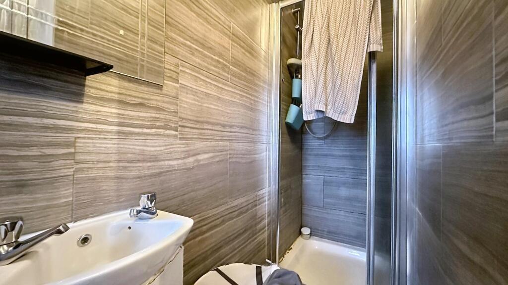 Modern tiled bathroom with a compact walk-in sh...