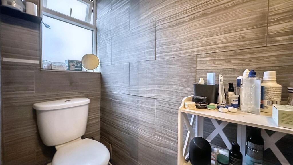 Compact tiled bathroom with a close-coupled toi...