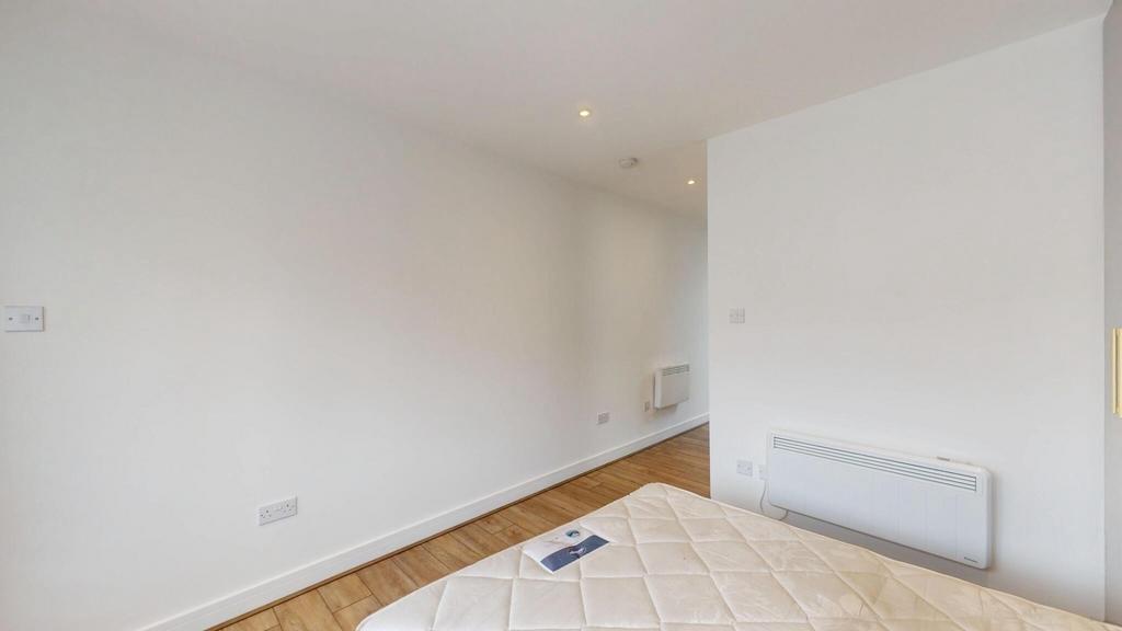Bright, simply furnished bedroom with clean whi...