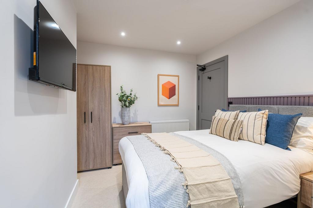 A stylish and spacious master bedroom featuring...