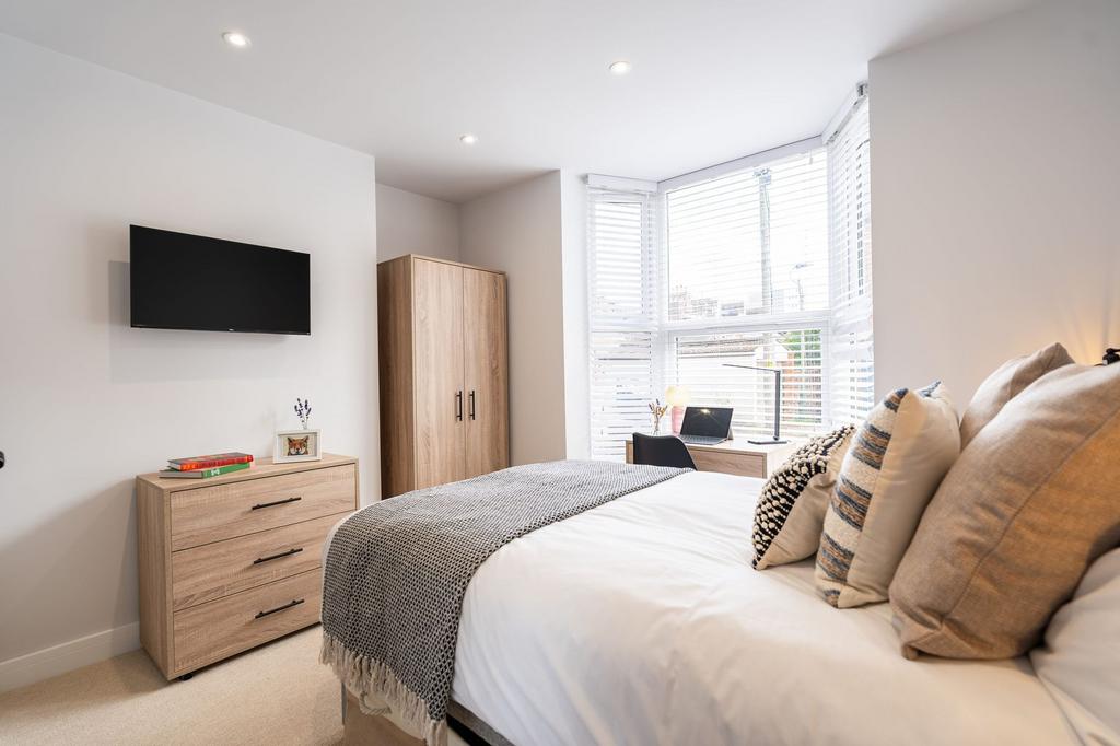 Bright and inviting bedroom with a large window...