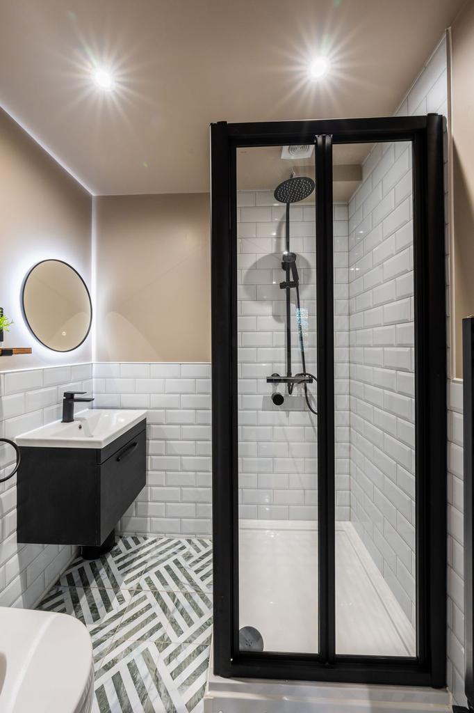 Modern bathroom with a glass-enclosed shower, s...