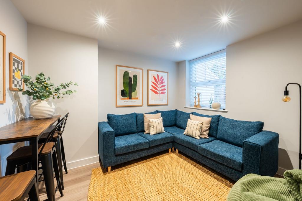 Bright, contemporary living room with a blue L-...