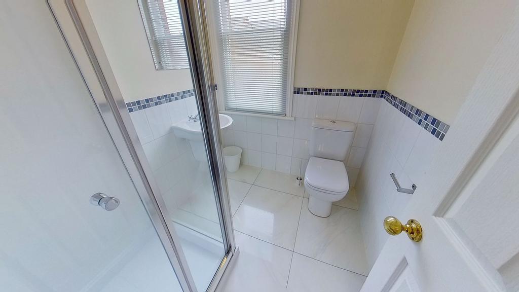 Bright, modern bathroom with a tiled shower enc...