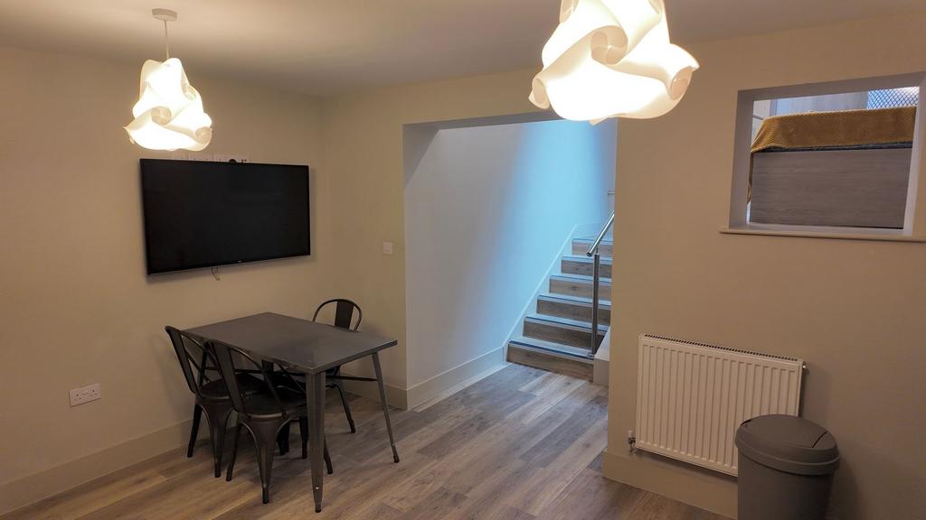 Bright, modern communal lounge with wall-mounte...