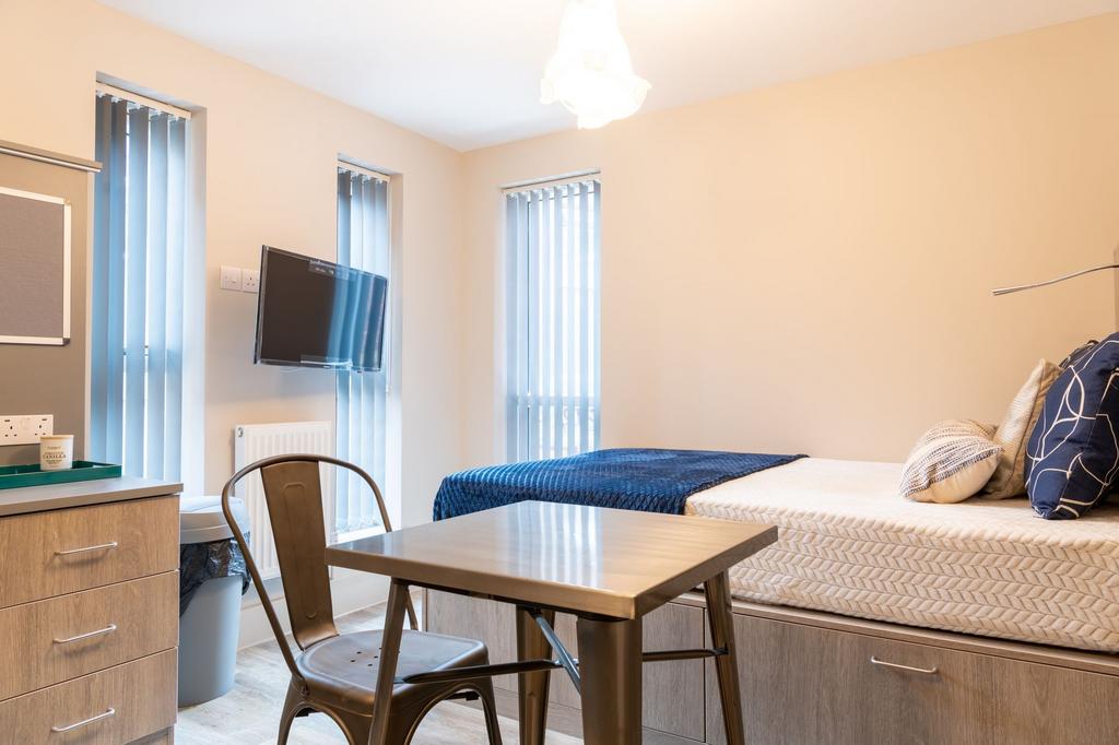 A bright and neatly organized single bedroom fe...