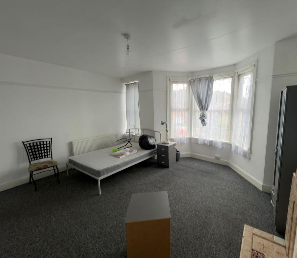 Bright, spacious bedroom with a large bay windo...
