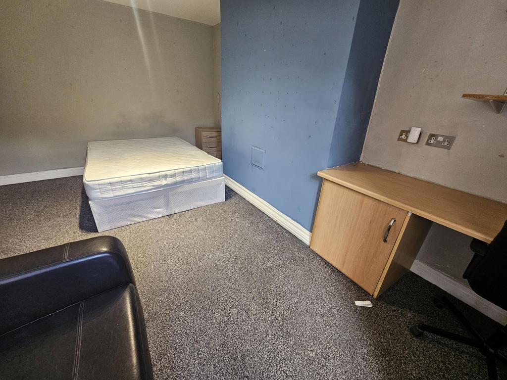 Bright, simply furnished bedroom with a double ...