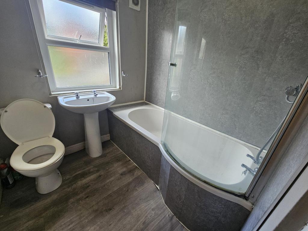 Bright, modern bathroom with a curved shower-ba...