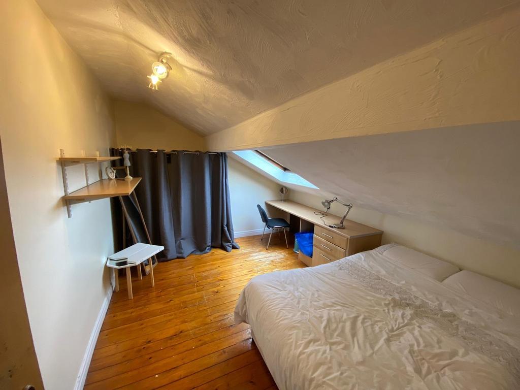 Cozy attic bedroom with a sloped ceiling, woode...
