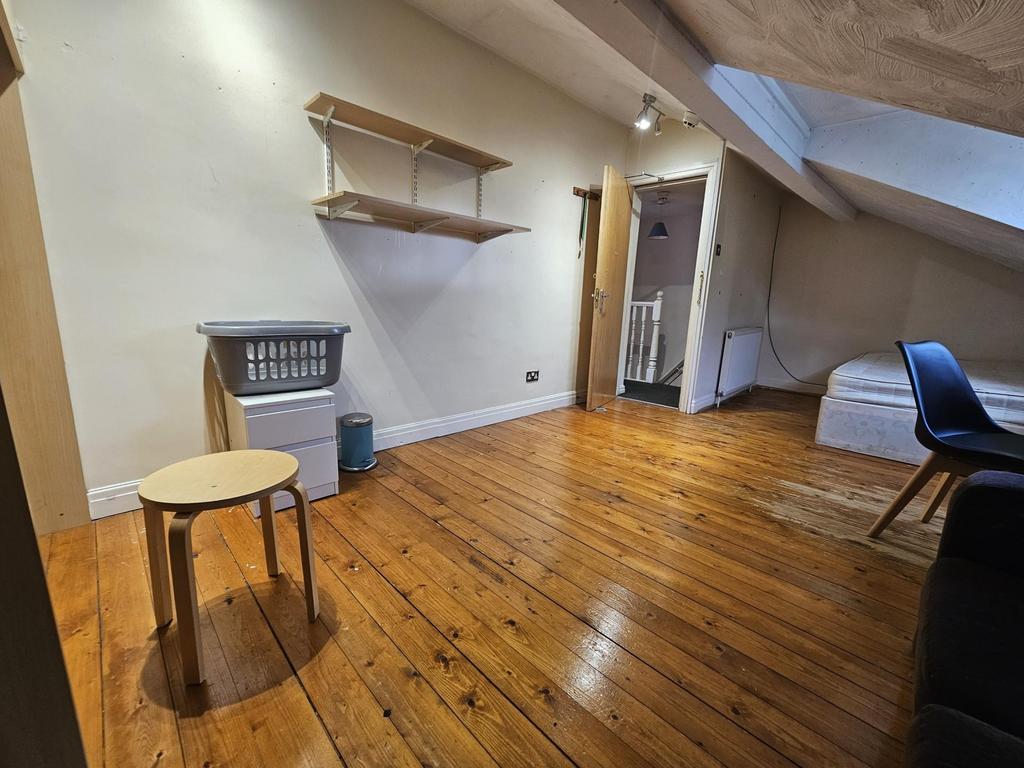 Bright attic bedroom with polished wooden floor...