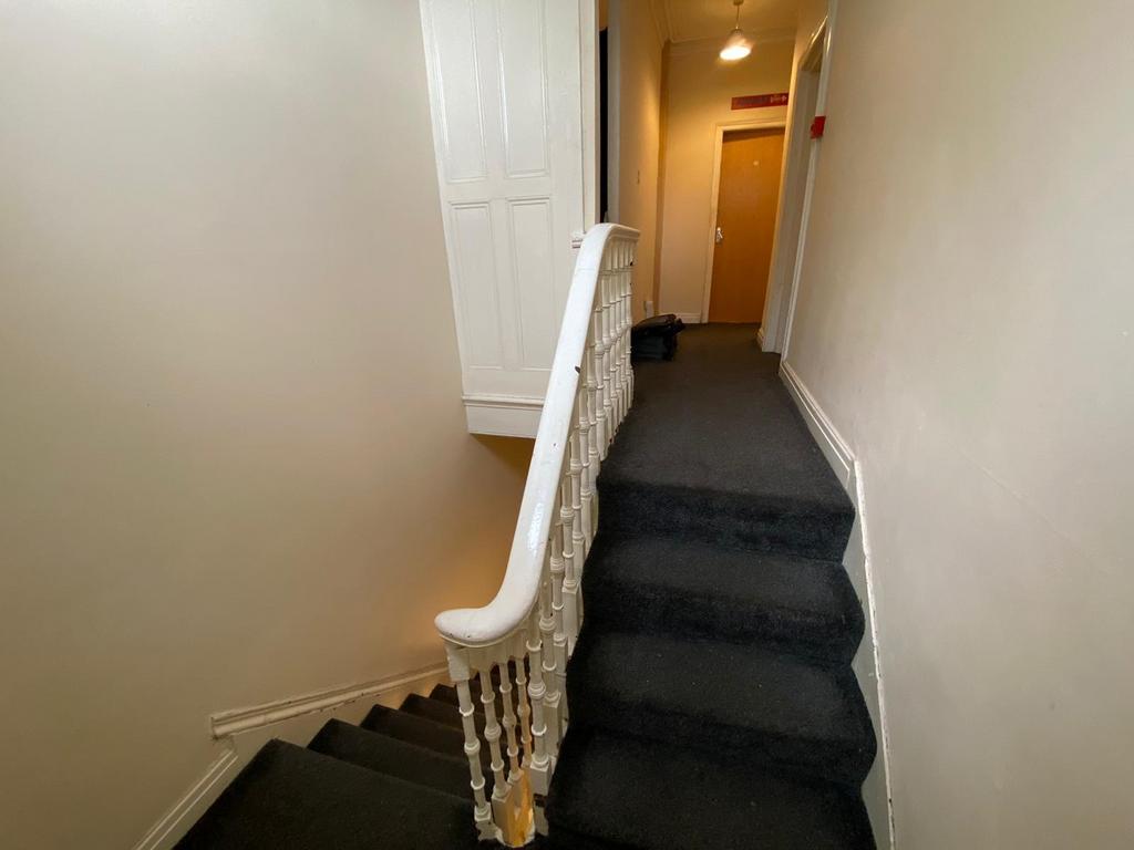Carpeted stairway and upper landing with white ...