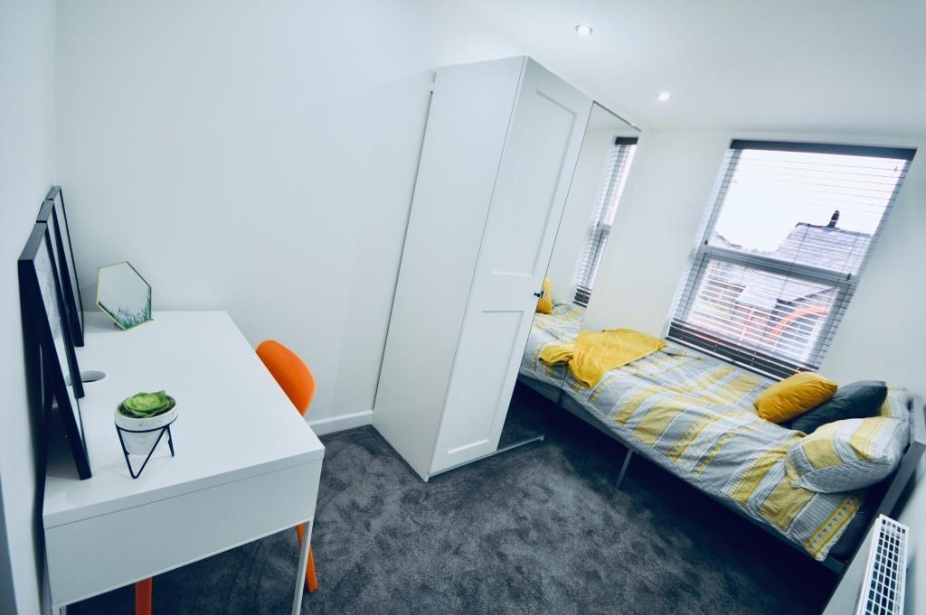 A well-lit, neatly maintained single bedroom wi...