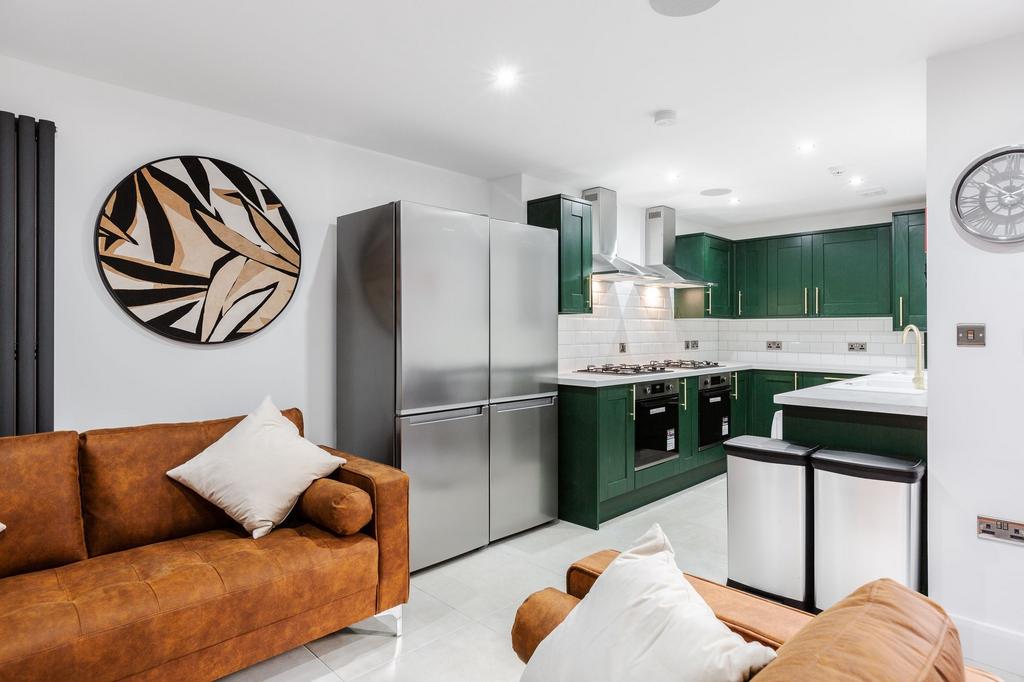 Modern kitchen with vibrant green cabinets, sta...