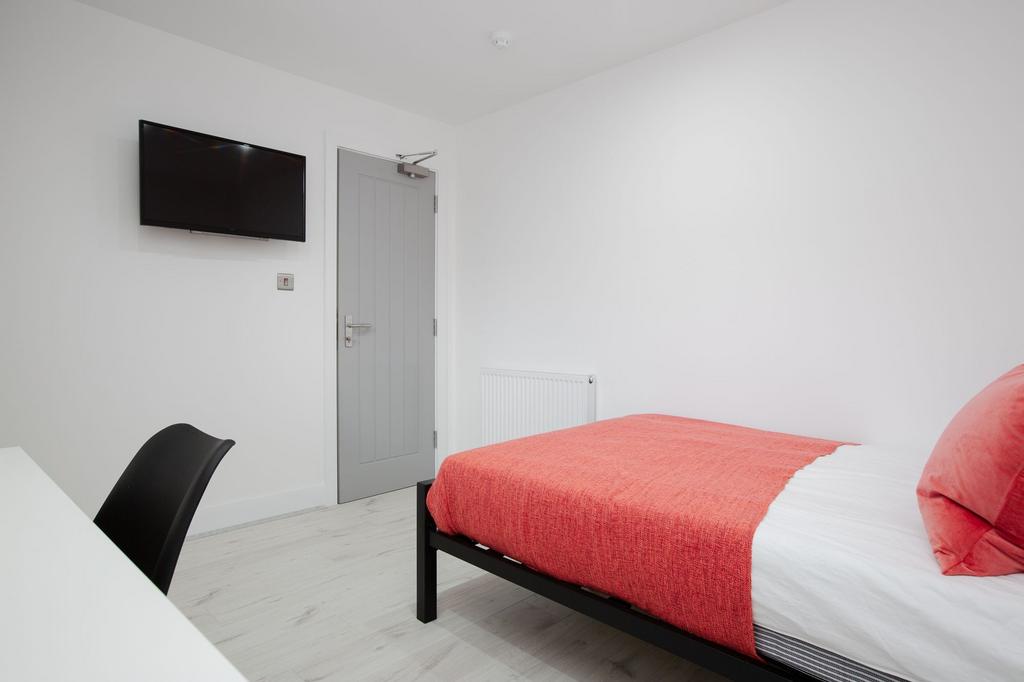 A bright and clean bedroom featuring a comforta...