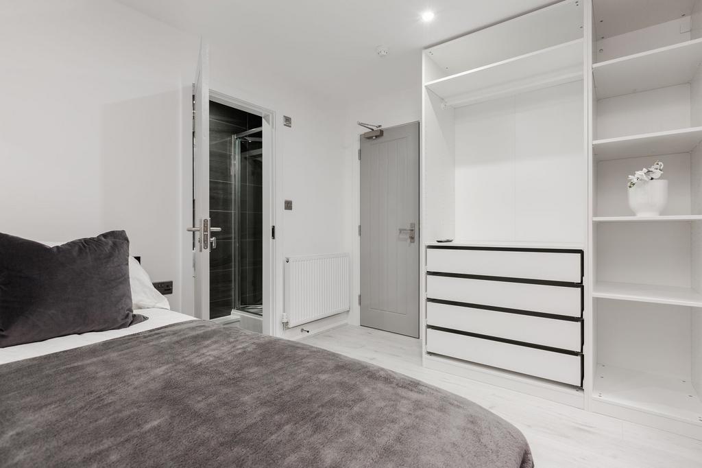 A clean and modern bedroom featuring a cozy bed...