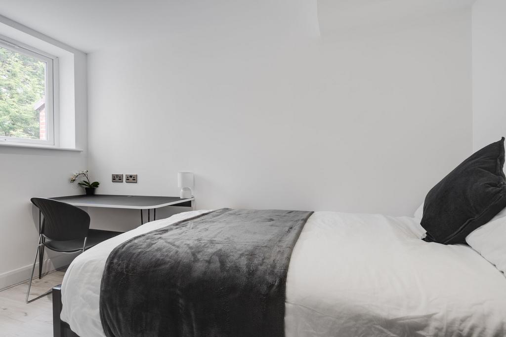 A modern, well-lit double bedroom featuring a c...