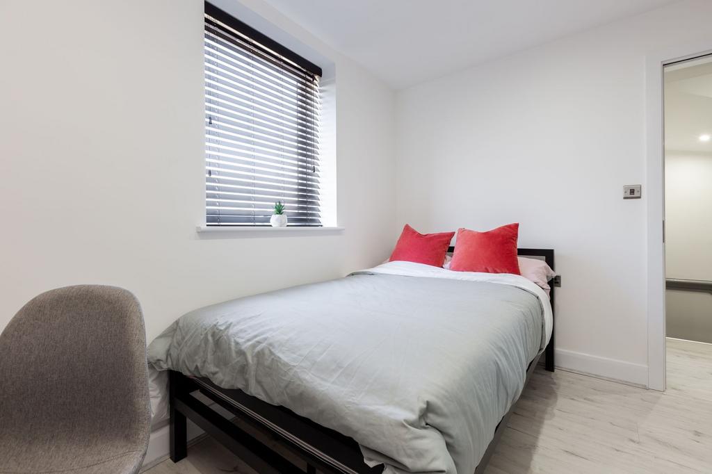 A bright and tidy bedroom featuring minimalisti...