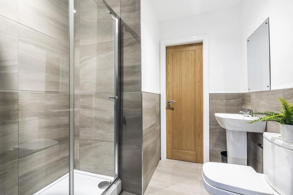Bright modern bathroom with a walk-in glass sho...