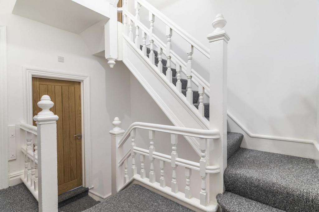 Bright, well-maintained staircase with crisp wh...