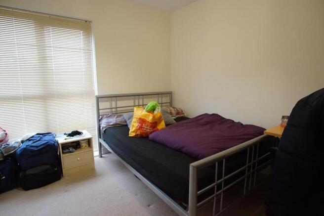 Simple, well-lit bedroom with a comfortable sin...