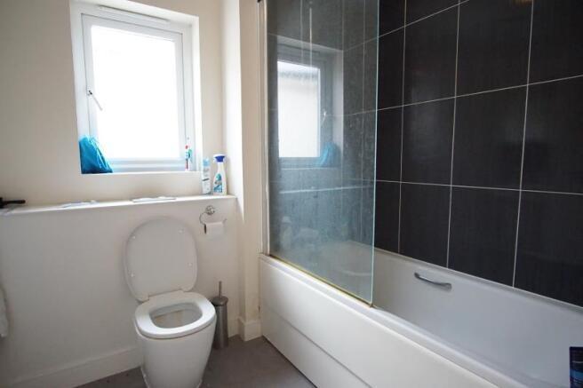 Bright, modern bathroom with a bathtub and over...
