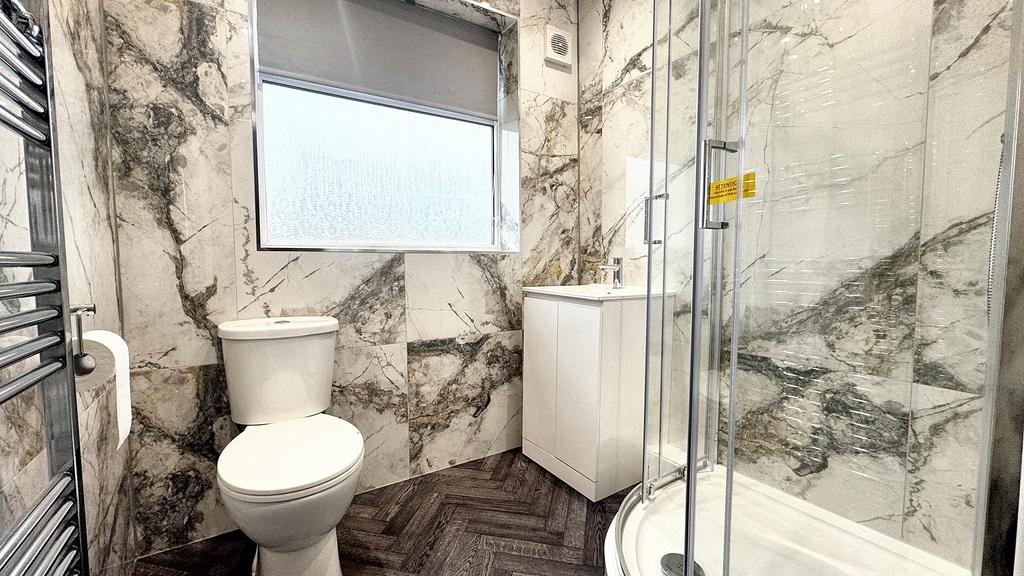 Bright, modern bathroom with marble-effect wall...