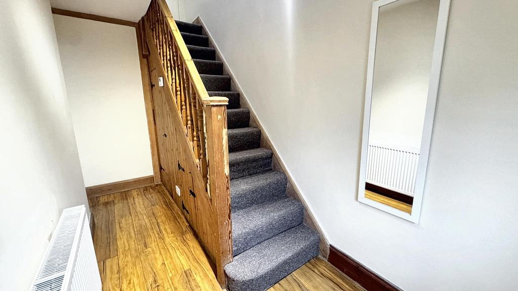 Bright, well-maintained hallway with wooden flo...