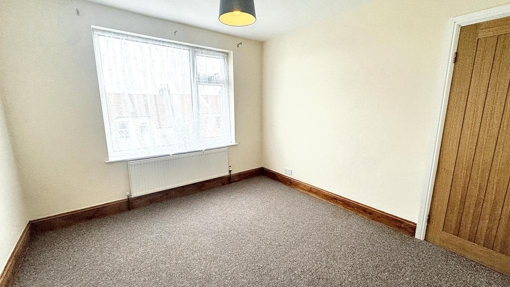 Bright, neutral bedroom with a large window, pa...
