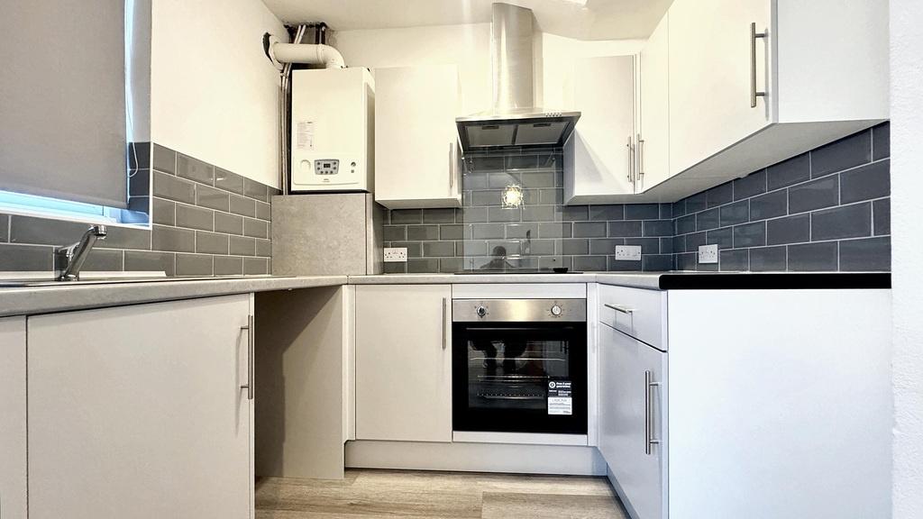 Bright modern kitchen with white cabinetry, int...